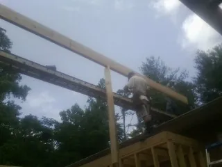 Carpenter setting a ridge beam over a new addition frame — Ice Dam Removal by Roofing Brothers in Clarkesville