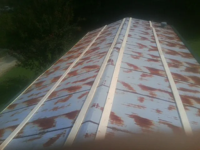 Rusted metal roof panels with new wood purlins before replacement — Storm Damage Roof Repair in Clarkesville by Roofing Brothers