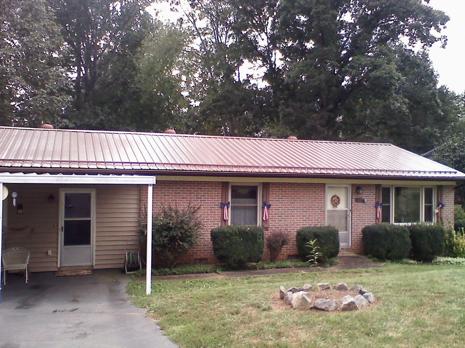 Bronze metal roof and carport on a brick ranch home — Roof Repair work by our crew in Clarkesville